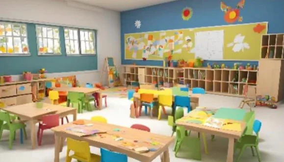 Sala com mesas coloridas, brinquedos e trabalhos expostos nas paredes.