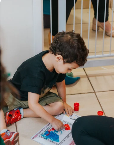 Criança pintando com as mãos em uma atividade de artes.
